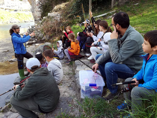 Grup de nens assistint a una classe de l'Escola de pesca del Pallars a tocar del riu Noguera Pallaresa | ACN